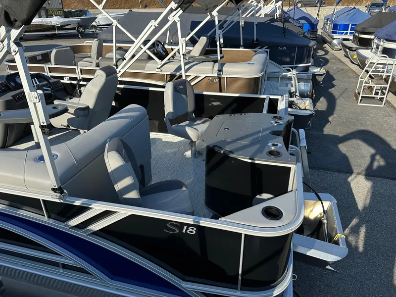 Slide: The Image of 2025 Bennington 188 SF Family pontoon boat with four fishing seats, docked outdoors. - 21