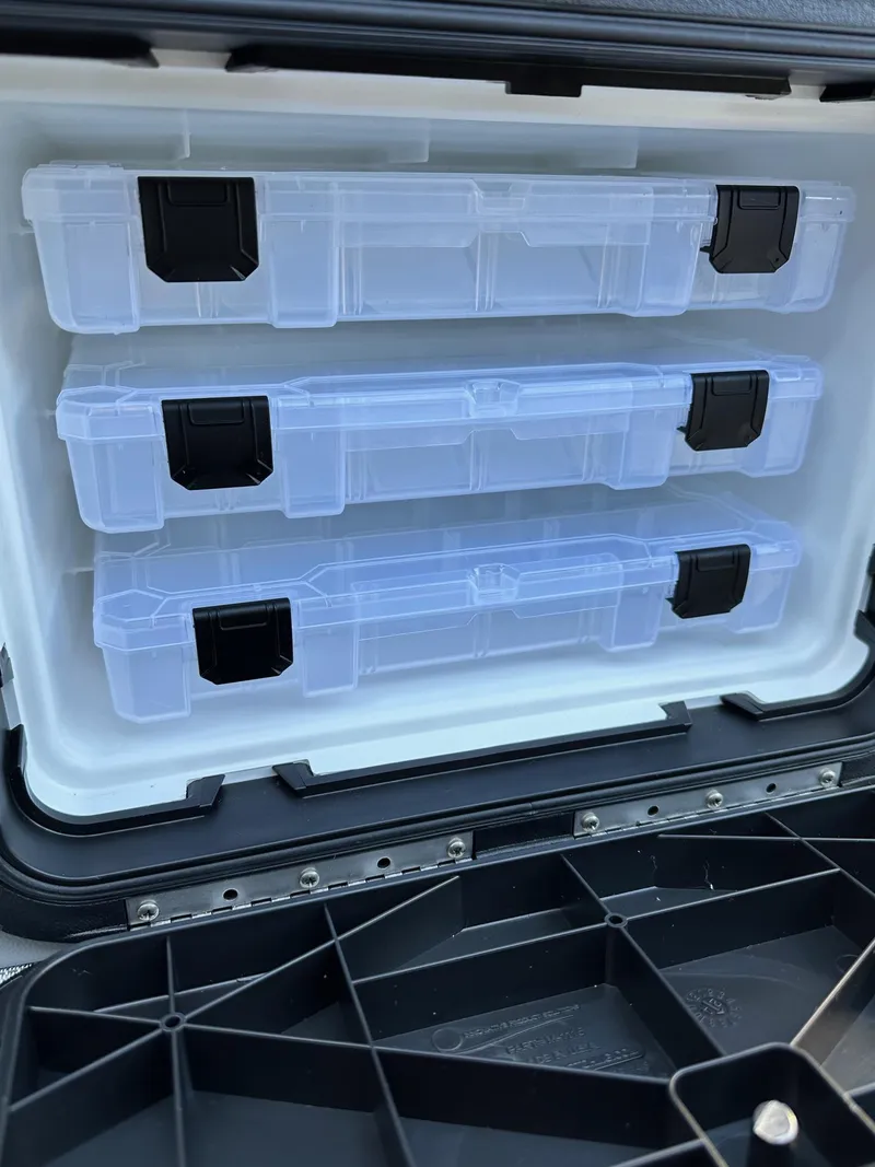 Slide: The Image of Clear tackle boxes in a storage compartment of a 2025 Bennington 188 SF Family boat. - 22