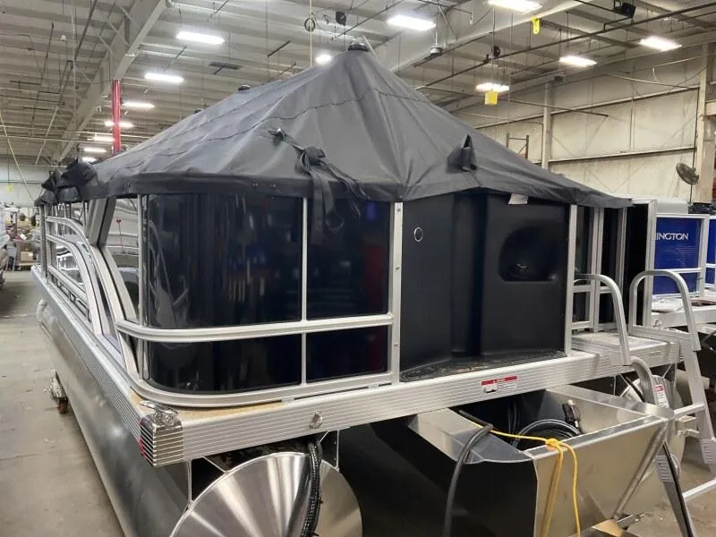 Slide: The Image of 2025 Bennington 188 SF pontoon boat with canopy in warehouse setting. - 9