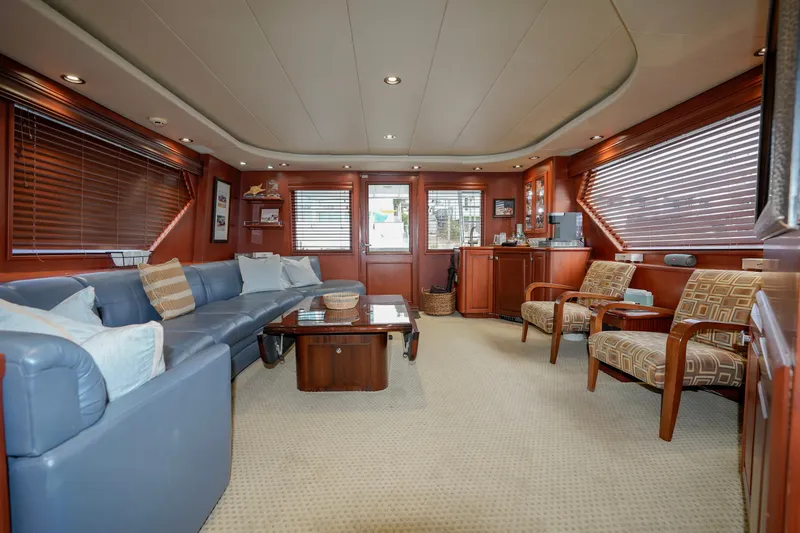 Slide: The Image of Luxurious interior of a 1997 Hatteras Sportfish yacht with plush seating and wooden accents. - 13