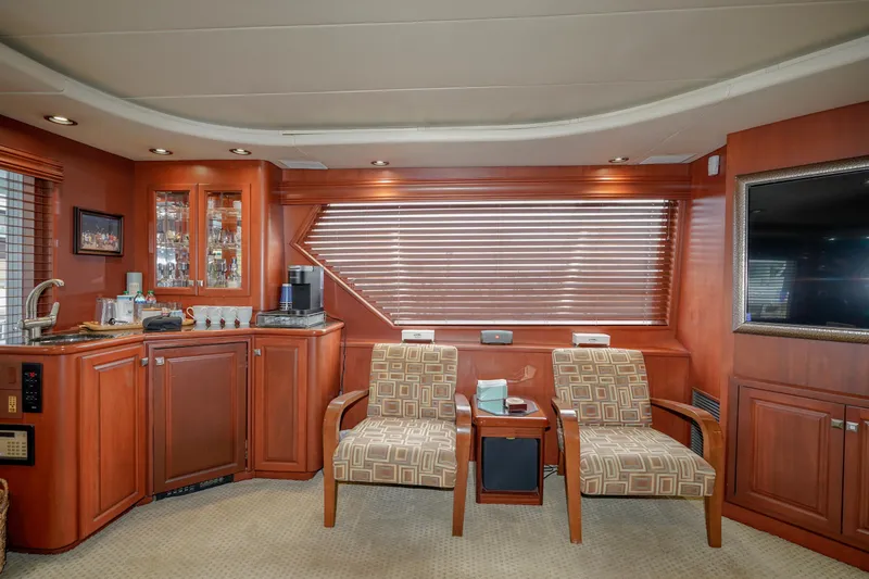 Slide: The Image of 1997 Hatteras Sportfish yacht interior with wooden cabinetry and seating area. - 14