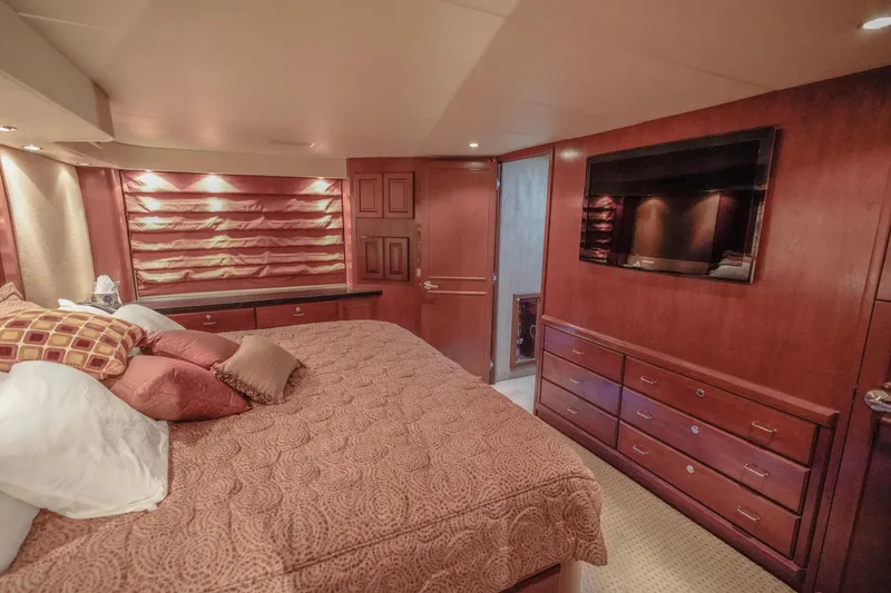Slide: The Image of Luxurious bedroom interior of 1997 Hatteras Sportfish yacht with wood furnishings and cozy bedding. - 22