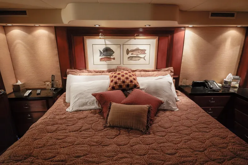 Slide: The Image of Luxurious bedroom interior of a 1997 Hatteras Sportfish yacht with plush bedding and framed fish artwork. - 25