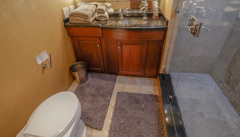 Slide: The Image of 1997 Hatteras Sportfish bathroom with wooden cabinets, glass shower, and modern fixtures. - 27