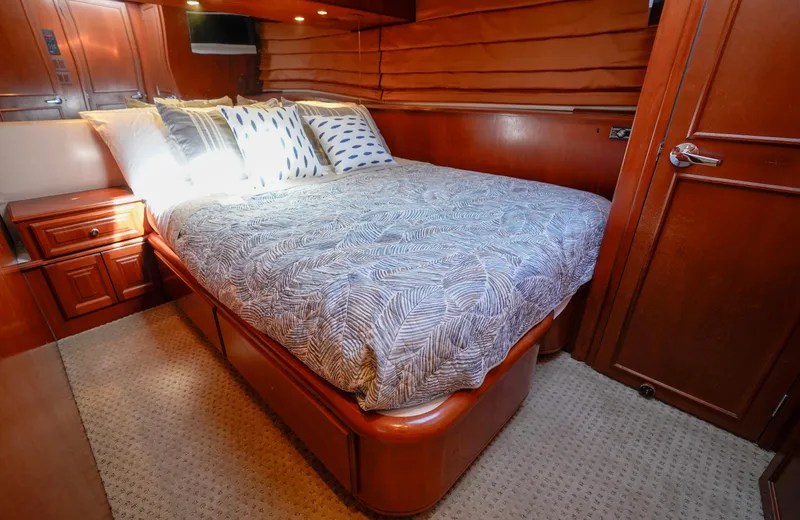 Slide: The Image of Luxurious bedroom interior of a 1997 Hatteras Sportfish yacht with wooden furnishings. - 38