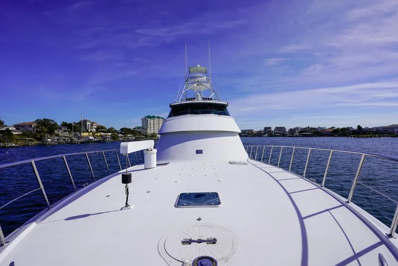 Slide: The Image of 1997 Hatteras Sportfish yacht on calm waters under a clear blue sky. - 4