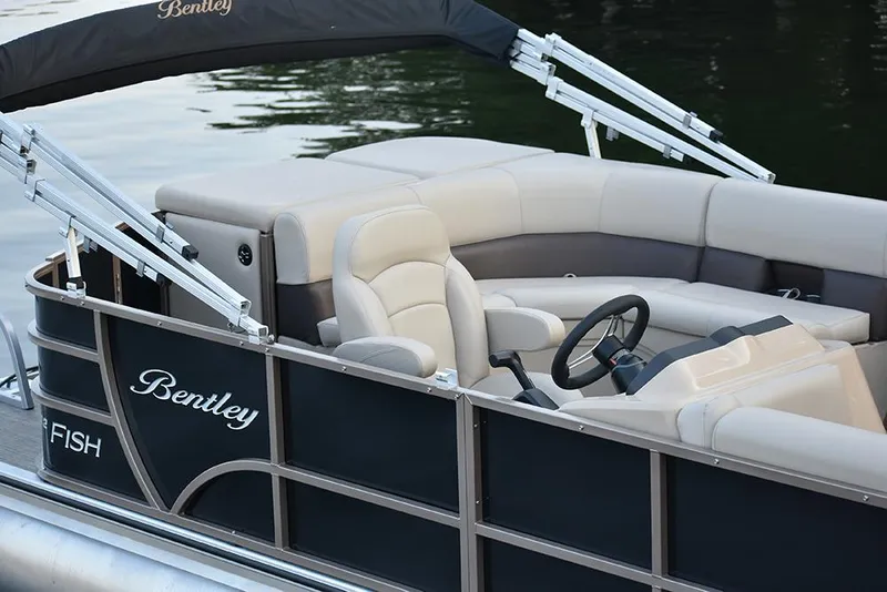 Slide: The Image of 2023 Bentley Pontoons FISH FORWARD FISH boat interior with beige seating and steering wheel. - 2