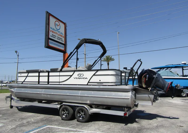 Slide: The Image of 2024 Veranda RELAX VR25RFL pontoon boat on trailer at Nautical Ventures dealership. - 1