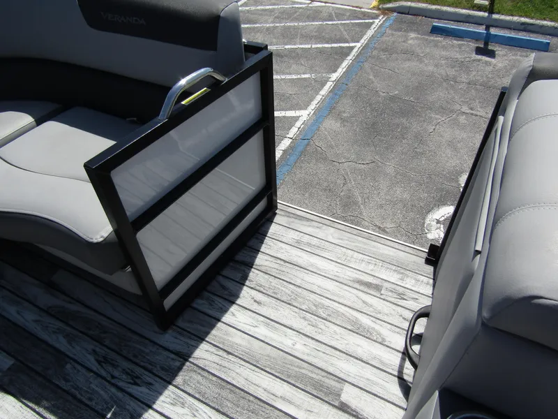 Slide: The Image of 2024 Veranda RELAX VR25RFL pontoon boat interior with gray seating and wood-style flooring. - 14