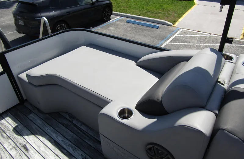 Slide: The Image of 2024 Veranda RELAX VR25RFL boat interior with gray seating and cup holders. - 27