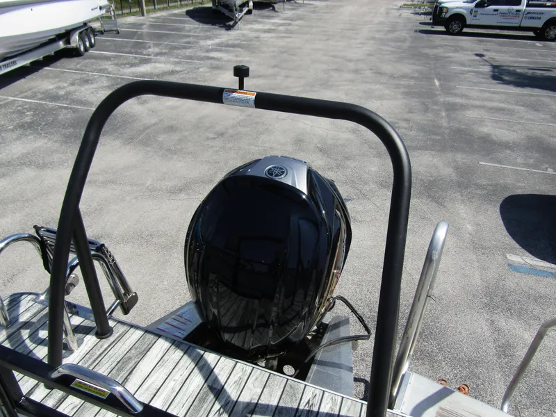 Slide: The Image of 2024 Veranda RELAX VR25RFL pontoon boat with outboard motor in a parking lot. - 31