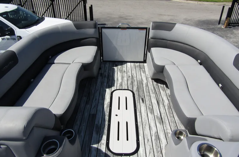 Slide: The Image of 2024 Veranda RELAX VR25RFL pontoon boat interior with gray seating and wood-style flooring. - 8