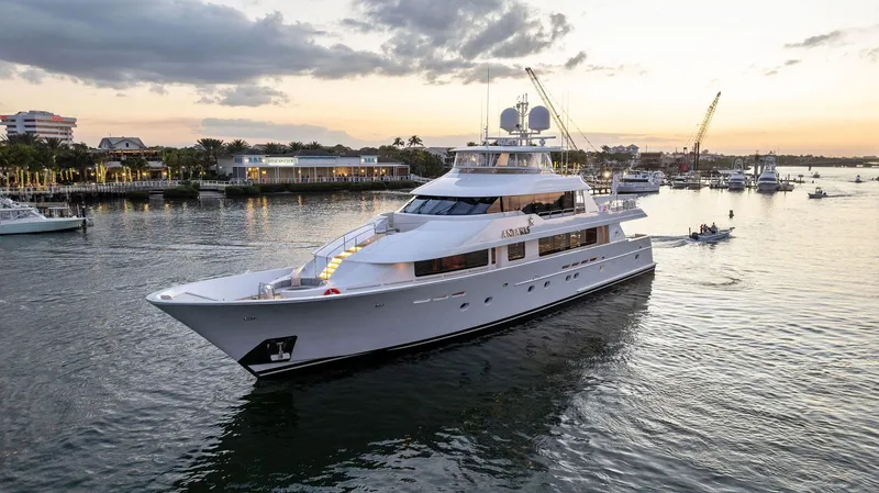 Slide: The Image of Luxury 2008 Westport 130 yacht cruising at sunset near a coastal city. - 11