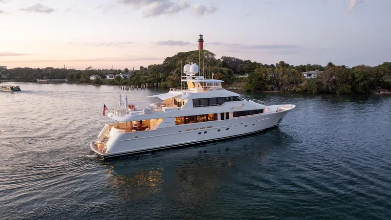 Slide: The Image of Luxury 2008 Westport 130 yacht cruising near a scenic shoreline at sunset. - 16