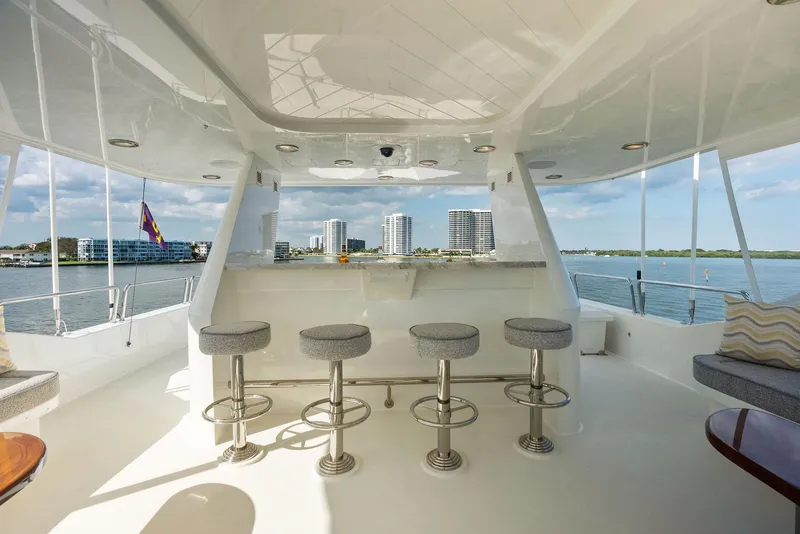 Slide: The Image of Luxurious 2008 Westport 130 yacht with bar stools and scenic waterfront view. - 22