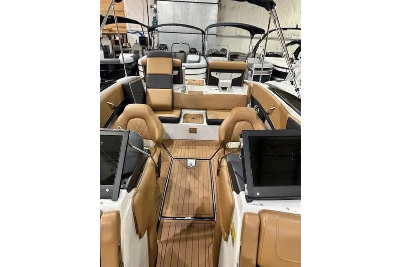 Slide: The Image of 2024 Crownline 220 SS LPX boat interior with tan leather seating and wood flooring. - 16