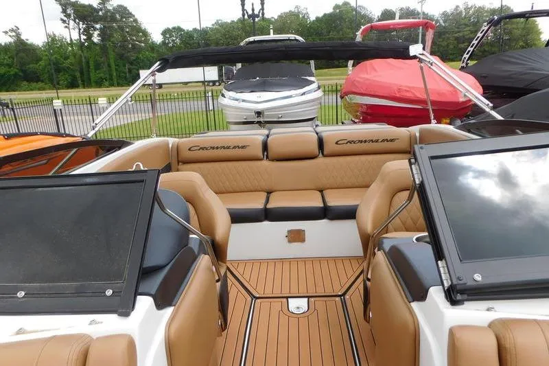 Slide: The Image of 2024 Crownline 220 SS LPX boat in showroom, front view, sleek design, luxury seating. - 4