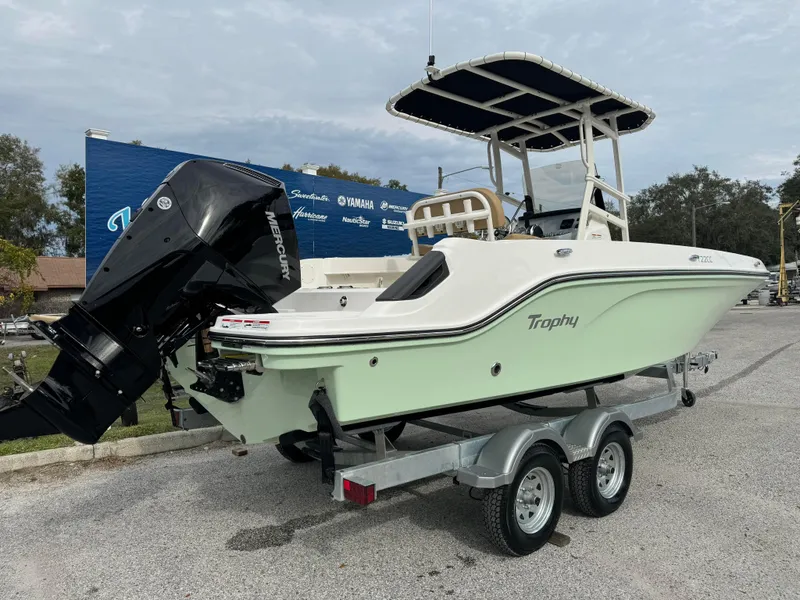 Slide: The Image of 2024 Bayliner Trophy CC22 boat on a trailer with a Mercury outboard motor. - 2