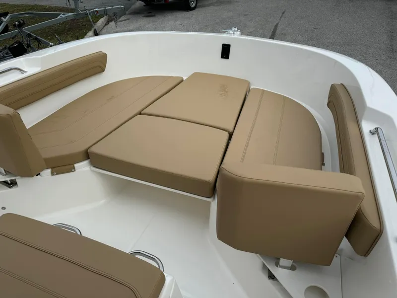 Slide: The Image of 2024 Bayliner Trophy CC22 boat with tan cushioned seating area. - 4