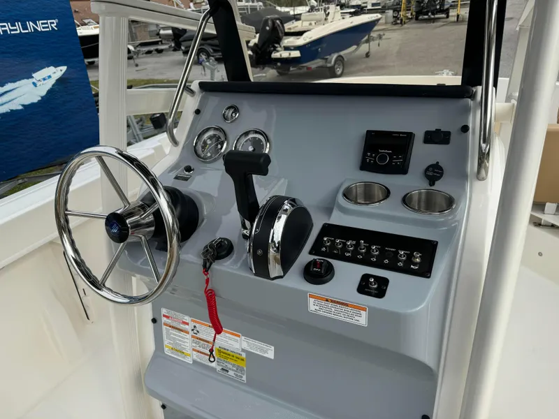 Slide: The Image of 2024 Bayliner Trophy CC22 boat console with steering wheel, controls, and gauges. - 6