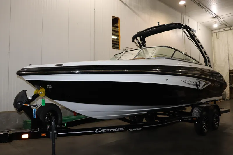 The Image of 2024 Crownline 240 SS SURF boat on trailer in indoor storage. - 1