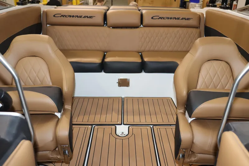 Slide: The Image of 2024 Crownline 240 SS SURF boat interior with tan leather seats and wood flooring. - 13