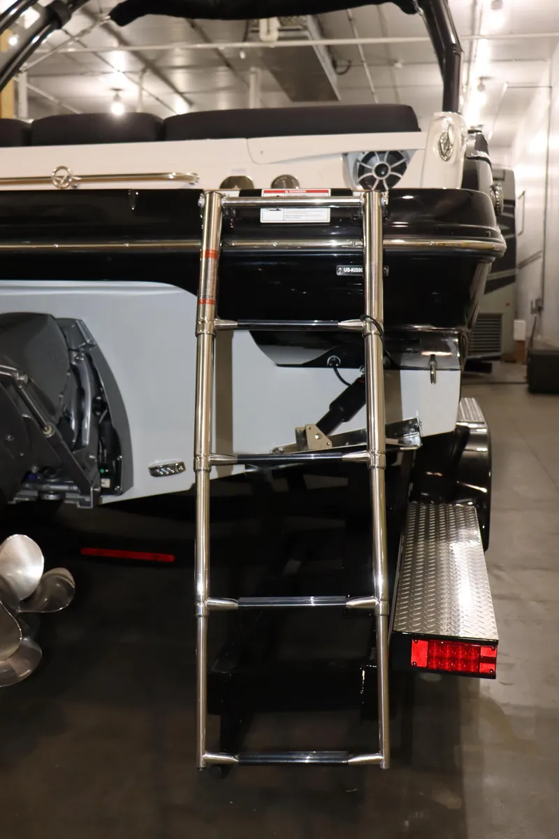 Slide: The Image of 2024 Crownline 240 SS SURF boat with rear ladder and trailer. - 25