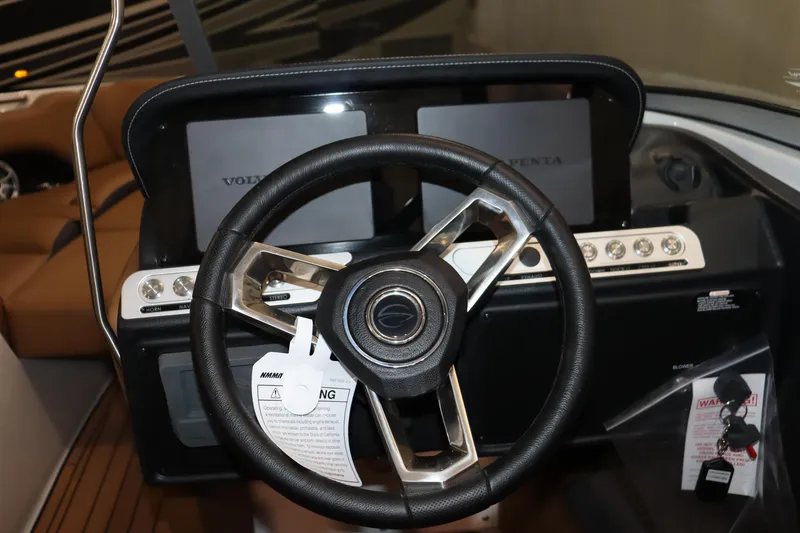 Slide: The Image of 2024 Crownline 240 SS SURF boat dashboard with steering wheel and control panels. - 9
