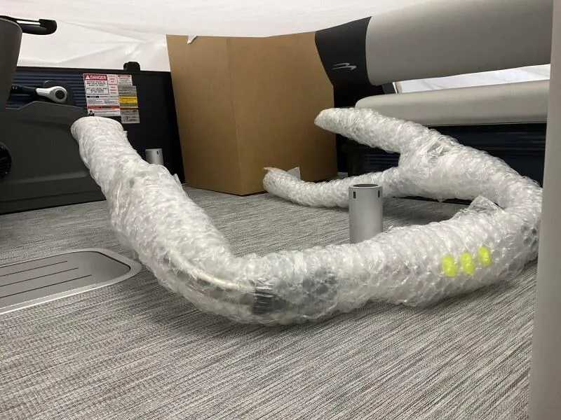 Slide: The Image of 2025 Bennington 22 SSB Tritoon interior with bubble-wrapped components on carpeted floor. - 6