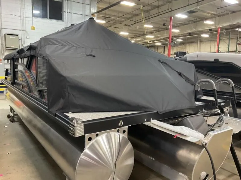 Slide: The Image of 2025 Bennington 22 SSB Tritoon with Yamaha F-150Hp, covered, in warehouse setting. - 9