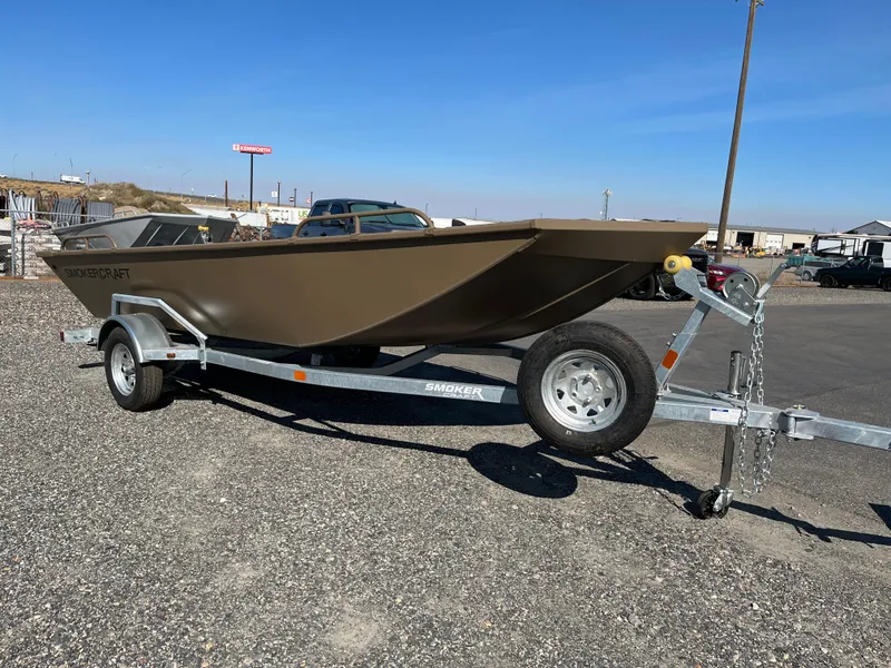 The Image of 2024 Smoker Craft 1660 Sportsman Pro boat on a trailer in a parking lot. - 0