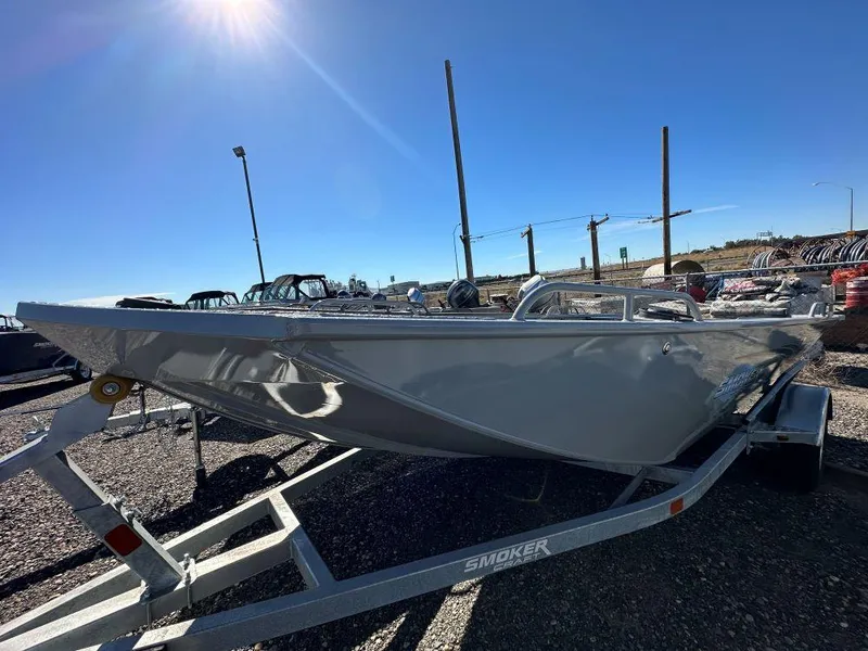 The Image of 2024 Smoker Craft 1660 Sportsman boat on a trailer under a clear blue sky. - 0