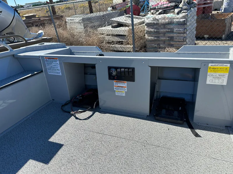 Slide: The Image of 2024 Smoker Craft 1660 Sportsman boat interior with storage compartments and control panel. - 2