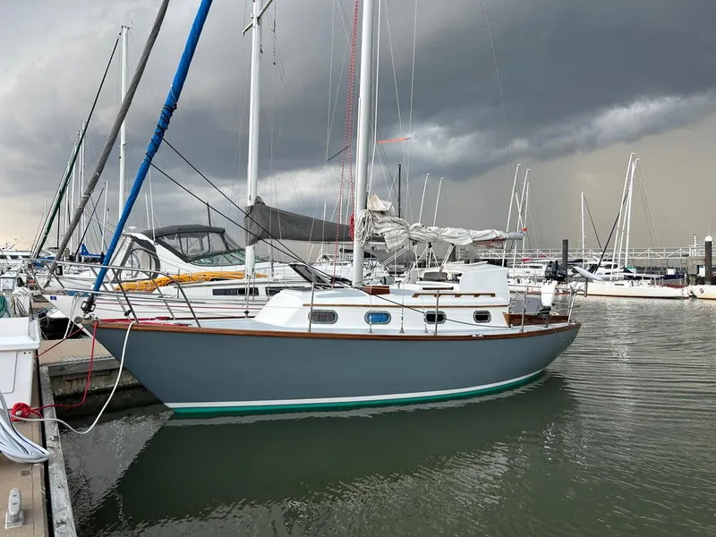 Slide: The Image of 1985 Cape Dory 270 sailboat docked at marina under stormy sky. - 1
