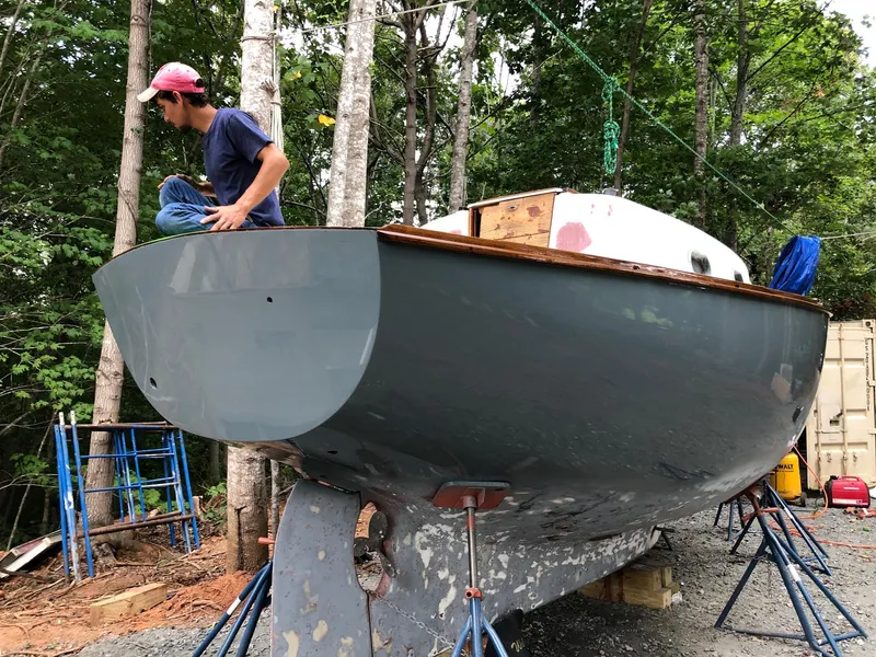 Slide: The Image of Man working on 1985 Cape Dory 270 sailboat hull in a wooded area. - 14