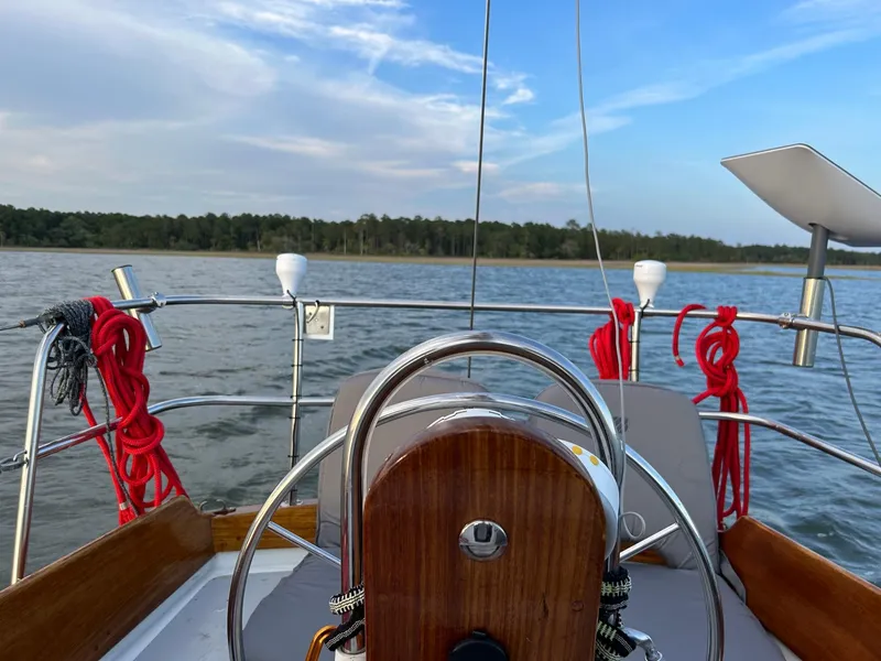 Slide: The Image of 1985 Cape Dory 270 sailboat cockpit with scenic water and forest view. - 25