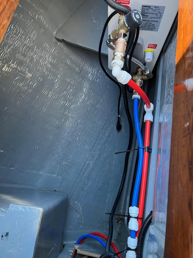 Slide: The Image of 1985 Cape Dory 270 boat interior plumbing system with red and blue pipes. - 31
