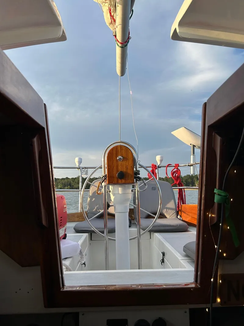 Slide: The Image of View from the cabin of a 1985 Cape Dory 270 sailboat, showing the helm and open sea. - 45