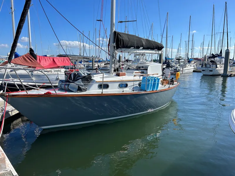 Slide: The Image of 1985 Cape Dory 270 sailboat docked in a marina on a sunny day. - 8