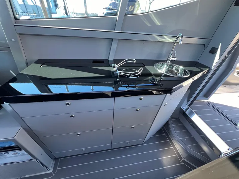 Slide: The Image of Modern kitchenette on the 2024 G-Force 10 boat with sleek black countertop and sink. - 16