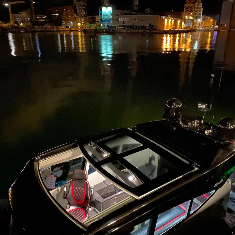 Slide: The Image of 2024 G-Force 10 boat docked at night with illuminated interior and waterfront reflections. - 38