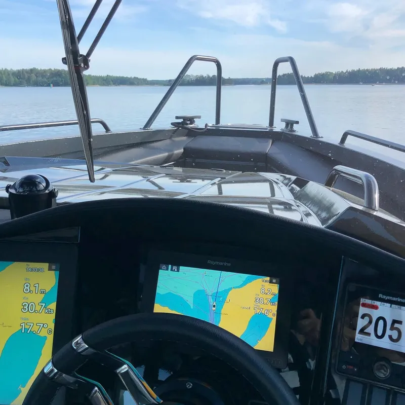 Slide: The Image of Cockpit view of 2024 G-Force 10 boat with navigation screens on a calm lake. - 39