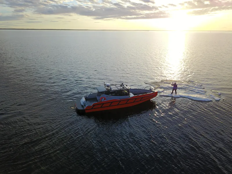 Slide: The Image of 2024 G-Force 10 boat on calm water at sunset with person on ice floe. - 40