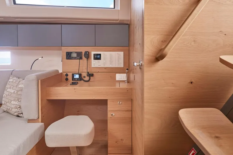 Slide: The Image of 2024 Elan Impression 43 yacht interior with navigation station and wooden finish. - 11