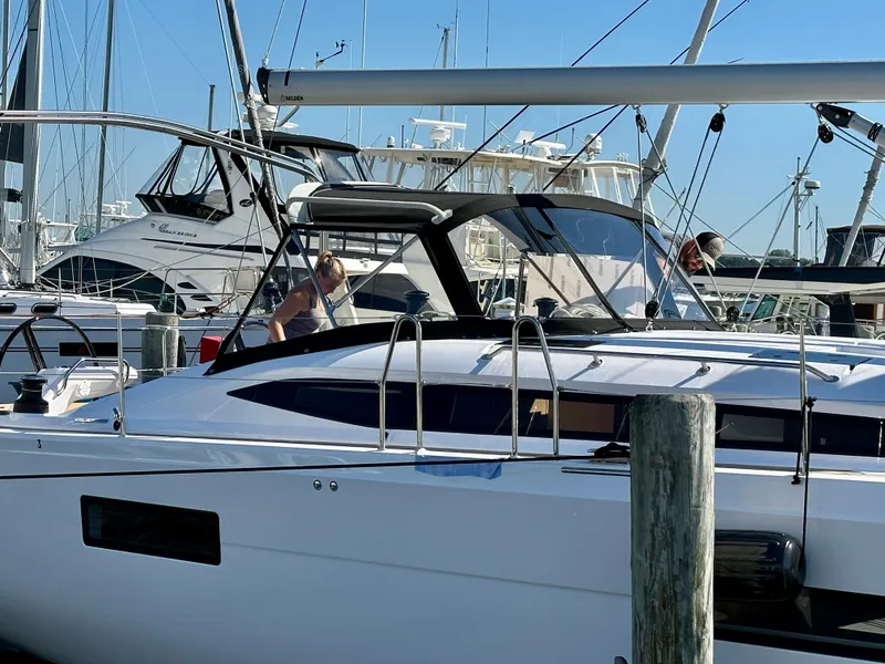 Slide: The Image of 2024 Elan Impression 43 yacht docked at marina with people onboard. - 2