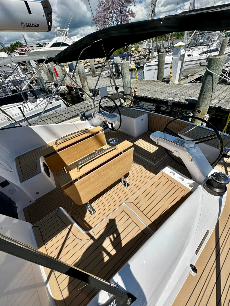 Slide: The Image of 2024 Elan Impression 43 yacht cockpit with wooden deck and dual steering wheels. - 22