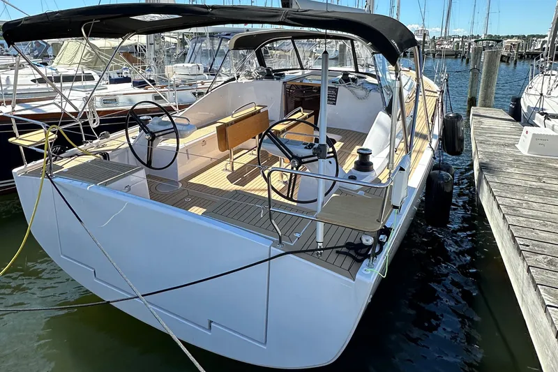 Slide: The Image of 2024 Elan Impression 43 sailboat docked at marina, featuring spacious cockpit and dual steering wheels. - 24