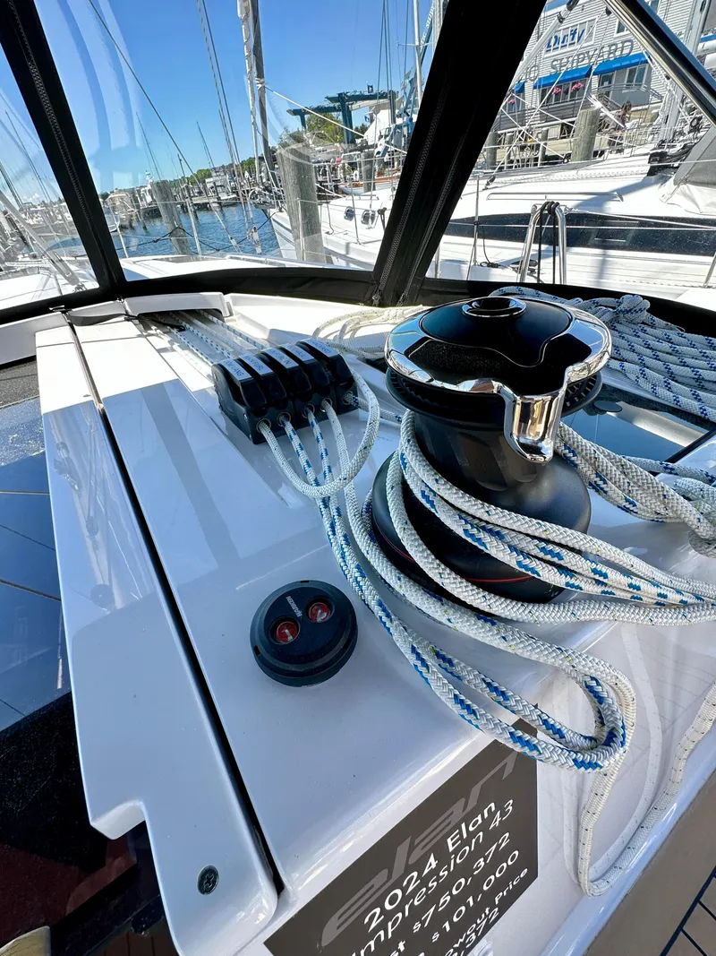 Slide: The Image of 2024 Elan Impression 43 sailboat deck with winch and ropes in marina. - 25