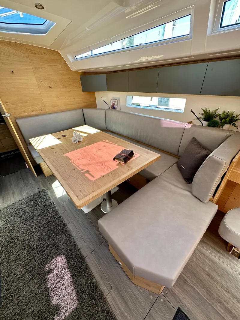 Slide: The Image of 2024 Elan Impression 43 yacht interior with modern seating and natural light. - 32