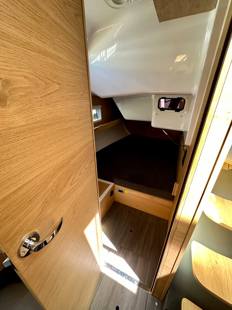 Slide: The Image of 2024 Elan Impression 43 yacht cabin interior with wooden finish and cozy sleeping area. - 36